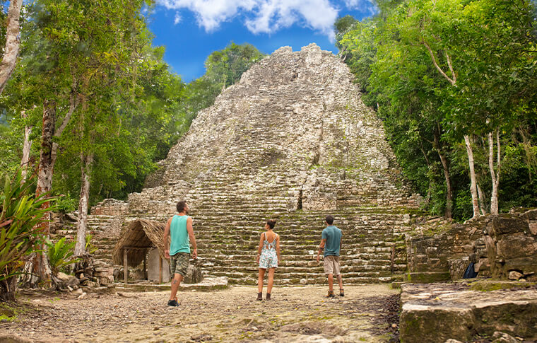 4 people at the base of the pyramid looking up